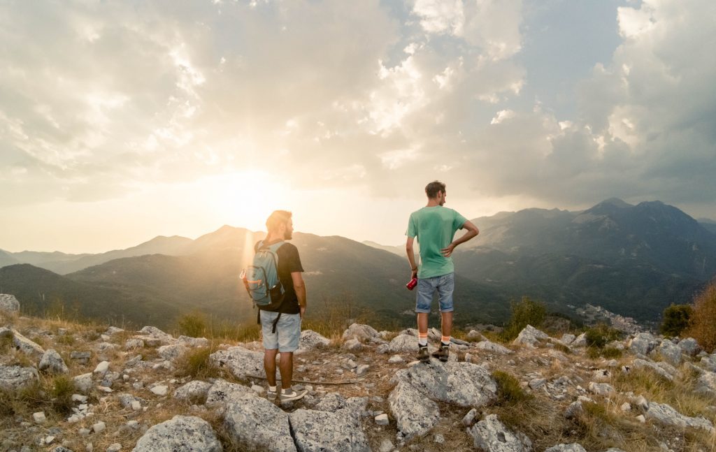 two men standing on top of the mountain